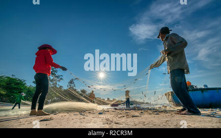 I pescatori stanno facendo la rete di pesca dopo la cattura come un modo di vivere nel villaggio costiero di pesca. Questo è duro lavoro, ma molte famiglie a Phan Thiet, Foto Stock