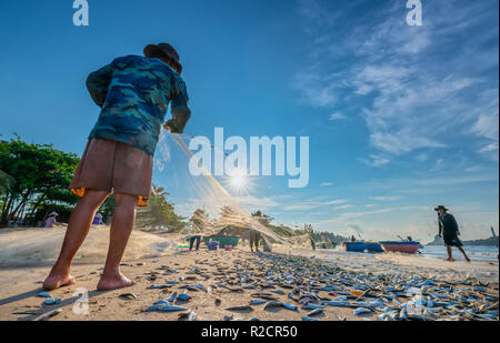 I pescatori stanno facendo la rete di pesca dopo la cattura come un modo di vivere nel villaggio costiero di pesca. Questo è duro lavoro, ma molte famiglie a Phan Thiet, Foto Stock