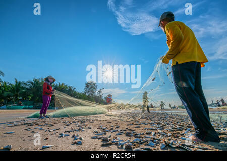 I pescatori stanno facendo la rete di pesca dopo la cattura come un modo di vivere nel villaggio costiero di pesca. Questo è duro lavoro, ma molte famiglie a Phan Thiet, Foto Stock