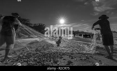 I pescatori stanno facendo la rete di pesca dopo la cattura come un modo di vivere nel villaggio costiero di pesca. Questo è duro lavoro, ma molte famiglie a Phan Thiet, Foto Stock