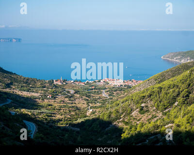 Piccola città Komiza sull isola di Vis in Croazia con isola Bisevo a sfondo Foto Stock