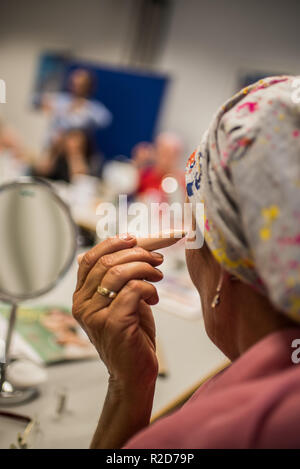 Mainz, Germania. Xix oct, 2018. Una donna con il cancro utilizza un mascheramento stick nel suo make-up classe. La terapia del cancro con chemioterapia o radioterapia possono modificare radicalmente l'aspetto della pelle con perdita dei capelli, perdita di ciglia e sopracciglia o irritazioni della pelle. Il tedesco donatori di midollo osseo (file DKMS) offerte per le donne interessate in particolare su di esso coordinato di make-up i corsi. (A dpa " con il make-up pennello e vernice contro le tracce di cancro' dal 19.11.2018) Credito: Andreas Arnold/dpa/Alamy Live News Foto Stock