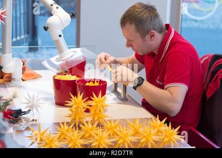 Herrnhut, Germania. Xv Nov, 2018. Dandy Krautz sta lavorando su una stella Herrnhut in plastica in mostra officina di Herrnhuter Sterne GmbH. La società tradizionalmente produce circa 250.000 stelle ogni anno in oltre 60 diverse varianti a mano. Credito: Sebastian Kahnert/dpa-Zentralbild/dpa/Alamy Live News Foto Stock