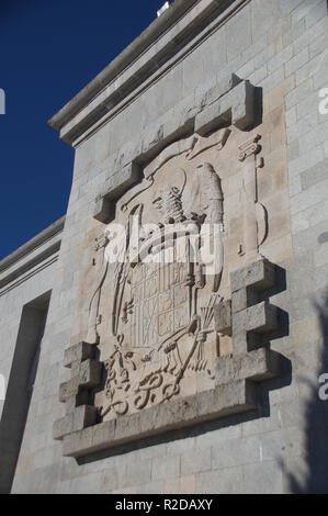 04 ottobre 2018, Spagna, El Escorial: un grande stemma dal periodo di Franco si blocca sul monumento nella Valle de los Caídos (Valle dei caduti), dove la tomba del dittatore Francisco Franco è situato a. Tre giorni dopo la sua morte, egli è stato sepolto nella Basilica il 23 novembre 1975. Il mausoleo, che è stato azionato nella roccia da 20.000 lavoratori forzati tra il 1940 e il 1959, è considerato uno dei più grandi del mondo. È il più importante simbolo architettonico della la dittatura di Franco. Accanto alla basilica, le ossa di più di 30.000 soldati morti durante la spagnola libe Foto Stock