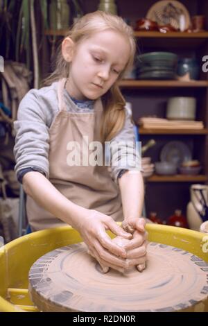 Laboratorio di ceramica - la ragazza fa un vaso di argilla su un tornio del vasaio Foto Stock