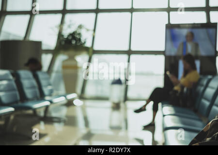 Sfondo sfocato,Traveler waitng per il volo in partenza Terminal in Aeroporto con bokeh,luce il concetto di trasporto Foto Stock