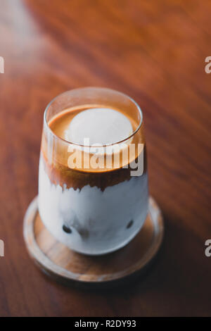 Uno bianco coppa piena di caffè espresso con crema marrone su porcellana  piattino con piccolo bricco per il latte sul vecchio vintage in legno di  bambù tabl Foto stock - Alamy