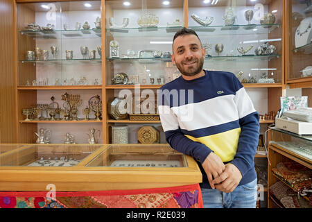 Poste ritratto di un Arabo ammassatore in un esclusivo negozio di articoli da regalo nella Città Vecchia di Gerusalemme, israeliane. Foto Stock