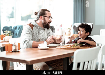 Bella bello piccolo ragazzo di mangiare formaggio squisita pizza Foto Stock