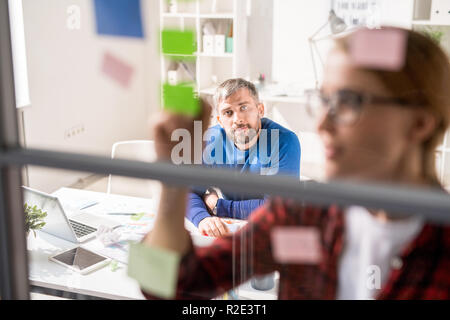 Malinconici marketer guardare la presentazione del collega Foto Stock