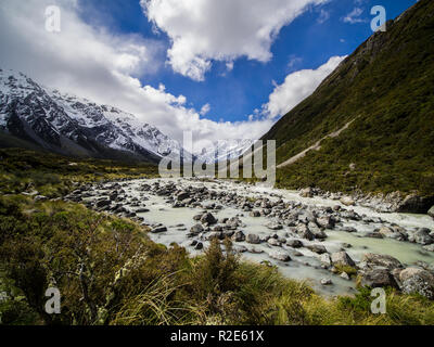 Viste maestose delle montagne innevate che si riflettono sul tranquillo lago sotto un cielo coperto Foto Stock