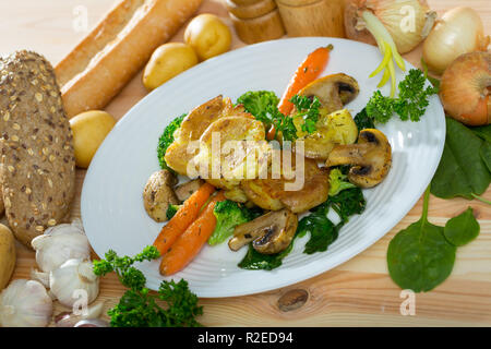 Tradizionale australiana Crash Hot Potatoes servita con funghi cotti, ortaggi e verdure Foto Stock