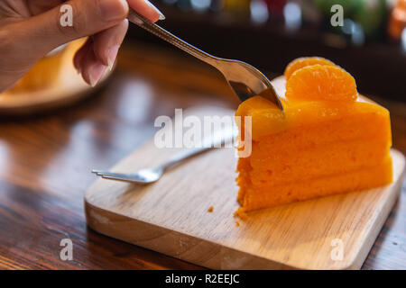Arancione di mangiare la torta su un tavolo di legno. Delizioso dolce torta alla frutta. Foto Stock