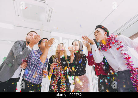 Felice anno nuovo partito colorato in office business persone divertimento insieme mix di gara. Foto Stock