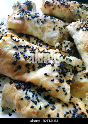 Tagliate i pezzi lavash con verdure. Burek con spinaci e formaggio e cumino nero. Yufka Foto Stock