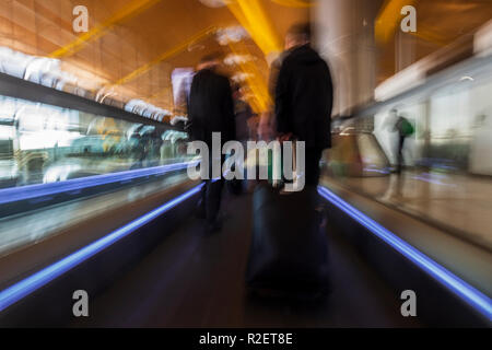 Aeroporto tapis roulants, tapis roulant, in movimento come i passeggeri a piedi con i loro bagagli a mano attraverso l'aeroporto Barajas di Madrid, Spagna, Foto Stock