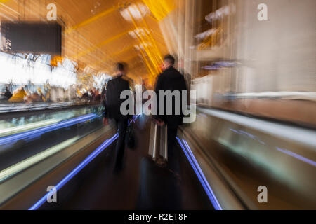 Aeroporto tapis roulants, tapis roulant, in movimento come i passeggeri a piedi con i loro bagagli a mano attraverso l'aeroporto Barajas di Madrid, Spagna, Foto Stock