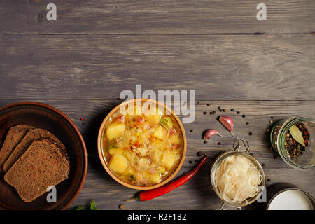 Zuppa di crauti nella ciotola con il nero rosso fnd pepe e foglie di alloro sul lato. Fotografato il sovraccarico di legno rustico.Copia dello spazio. Foto Stock