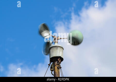 Tazza semisferica anemometro per la velocità del vento manometro girano a velocità in alta venti forti. Stazione meteo strumento sulla North Weald airfield. Nuvole, cielo Foto Stock