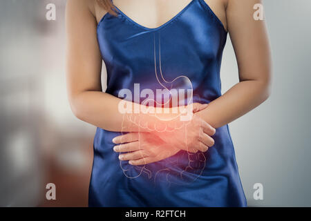 Donna asiatica in camicia da notte in raso wake up per andare alla toilette, la foto di organi interni è sulle donne del corpo contro il wc sfondo, Healthcare Foto Stock