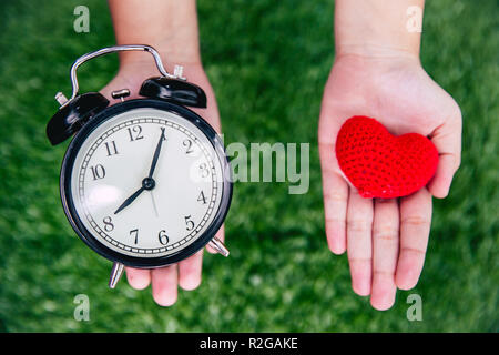 Dare amore volte cuore e orologio sulla ragazza mano. Foto Stock