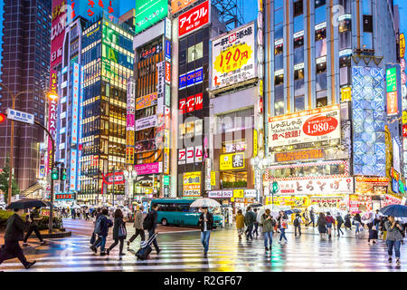 Tokyo, Giappone - Sep 28th 2018 - un grande gruppo di persone a piedi attorno a una coloratissima e luminosa area di Tokyo in un giorno di pioggia in Giappone Foto Stock