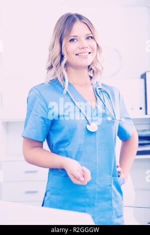 Ragazza medico sorge nei pressi di un tavolo in ufficio Foto Stock