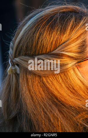 Treccia di capelli biondi su una giovane donna come visto dalla parte posteriore della sua testa close up Foto Stock