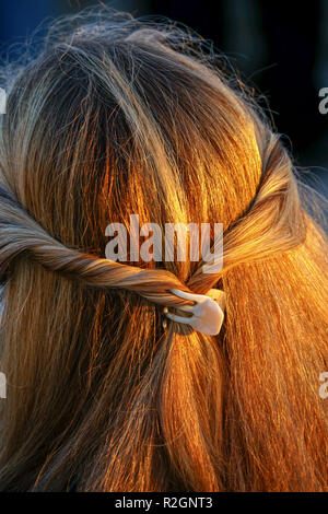 Treccia di capelli biondi su una giovane donna come visto dalla parte posteriore della sua testa close up Foto Stock