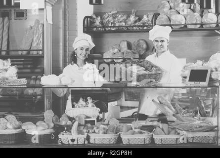 Uomo felice e una ragazza la vendita di pasticceria fresca e focacce di pane in sezione Foto Stock