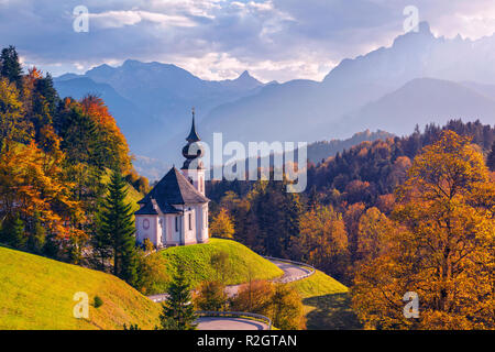 Autunno nelle Alpi. Immagine delle Alpi Bavaresi con Maria Gern Chiesa e monte Watzmann durante il bellissimo tramonto d'autunno. Foto Stock