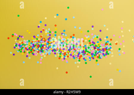 Coriandoli colorati su sfondo giallo. Foto Stock