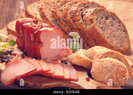 Vetri fatti in casa prosciutto affumicato con fresche erbe aromatiche e spezie aromatiche, close up vista vintage Foto Stock