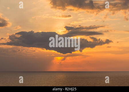 Drammatica piercing di luce attraverso le nuvole e colpire il mare. Foto Stock
