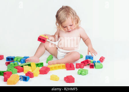 Bambina gioca con la costruzione di blocchi su sfondo bianco Foto Stock