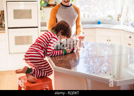 Ragazzo aiutando il padre cuocere Foto Stock