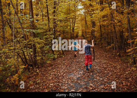 Un ragazzo e una ragazza a piedi attraverso una foresta di inizio autunno, Stati Uniti Foto Stock