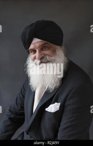 Ritratto sorridente, fiduciosi ben vestito uomo anziano con la barba in turbante Foto Stock