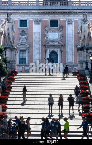 I turisti sui gradini che conducono alla Piazza del Campidoglio e i Musei Capitolini, sulla sommità del colle capitolino, guardando verso la facciata del Foto Stock