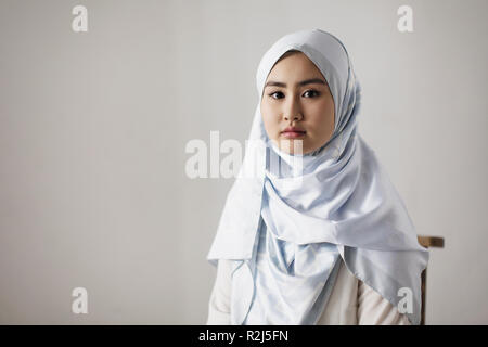Ritratto fiduciosi, grave giovane donna indossa hijab Foto Stock