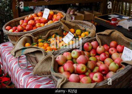 Le mele e le clementine per la vendita in cesti in un mercato mediterraneo un prezzo in euro Foto Stock