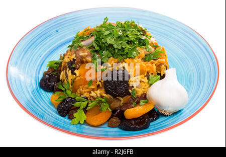 Riso pilaf con carni di montone, di albicocche e prugne secche, aglio ed erbe aromatiche. Isolato su sfondo bianco Foto Stock