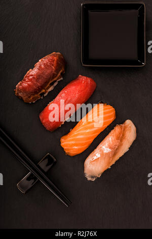 Vista superiore del delizioso sushi sashimi su nero ardesia Foto Stock