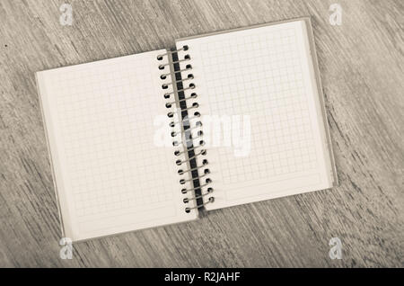 Notebook a spirale con pagine vuote giacenti su una superficie di legno Foto Stock