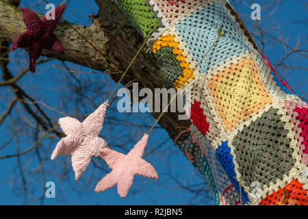 Chiudere fino a maglia rosa di natale tessile stelle pendente dal filato albero di bomba Foto Stock