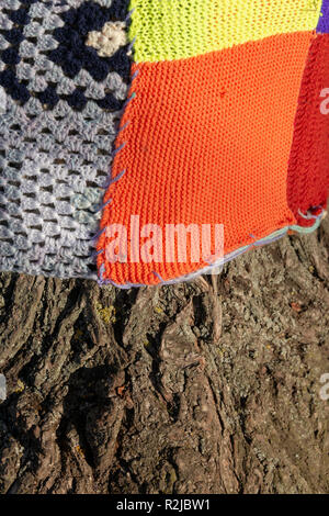 Chiudere fino a maglia pannelli patchwork attorno al tronco di albero Foto Stock
