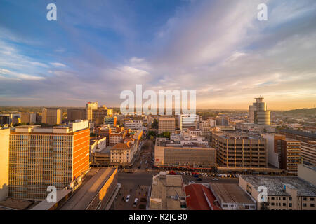 Un tramonto è visto oltre il Harare skyline della città in Zimbabwe Foto Stock