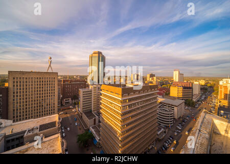 Un tramonto è visto oltre il Harare skyline della città in Zimbabwe Foto Stock