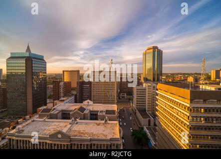 Un tramonto è visto oltre il Harare skyline della città in Zimbabwe Foto Stock