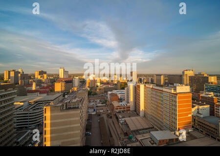 Un tramonto è visto oltre il Harare skyline della città in Zimbabwe Foto Stock